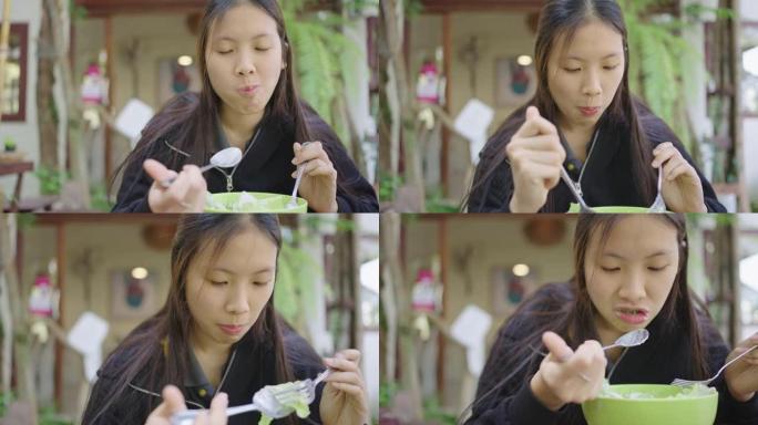 快乐的年轻亚洲妇女在户外客厅吃沙拉