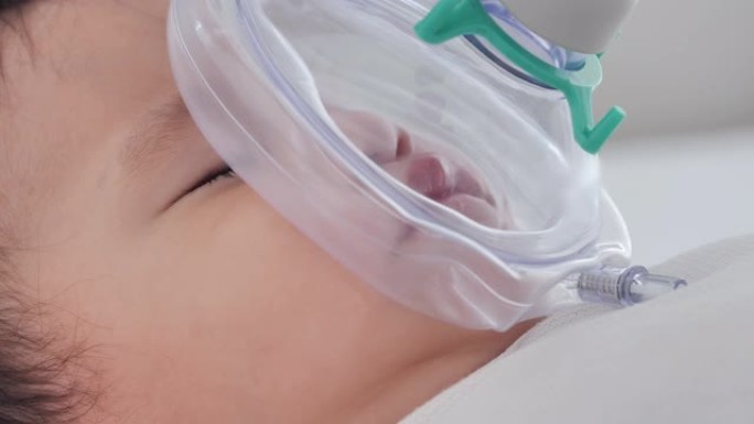 亚洲小男婴患哮喘在家床上戴吸入器口罩日常哮喘护理