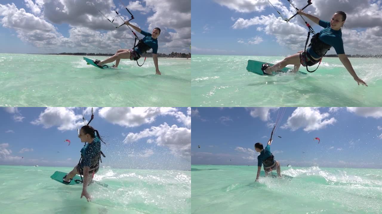 特写: 坦桑尼亚的快乐女人风筝冲浪将她的手拖到玻璃般的海洋上