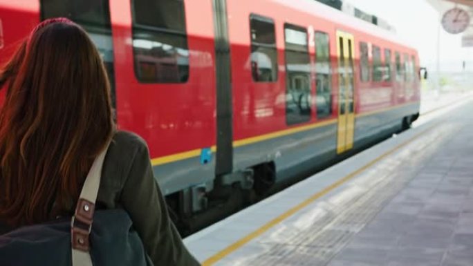 年轻女子带着行李走在铁路平台上