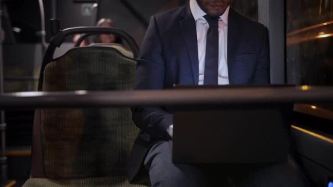 特写非裔美国人商人在公共巴士上使用笔记本电脑