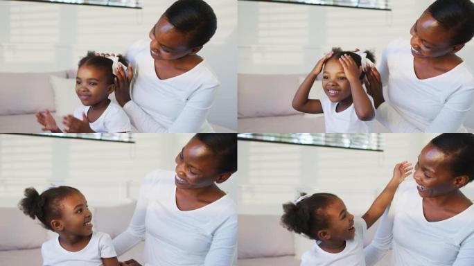 快乐的非裔美国母女坐在床上，母亲放发弓