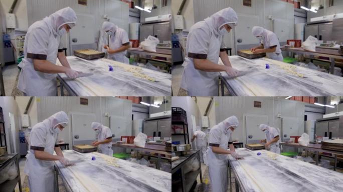 拉丁美洲男子在一家工业面包店切割糕点