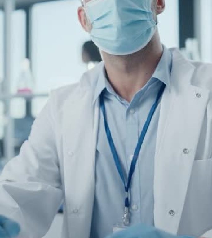 现代医学研究实验室: 科学家戴着口罩与移液器一起工作，分析生物技术样本，交谈。先进的药物科学实验室，