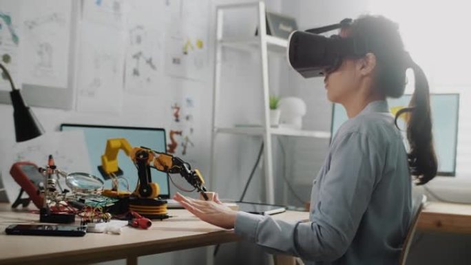工程师戴着虚拟现实耳机，坐在办公桌前工作时打手势