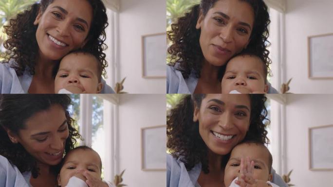快乐的妈妈和宝宝使用智能手机进行视频聊天妈妈分享母亲的生活方式抱着蹒跚学步的孩子享受在家与家人的手机