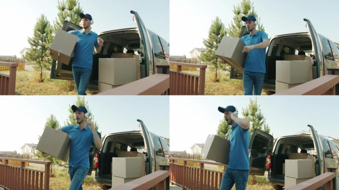 快乐的送货员戴着耳机享受音乐，从面包车把包裹带到家里