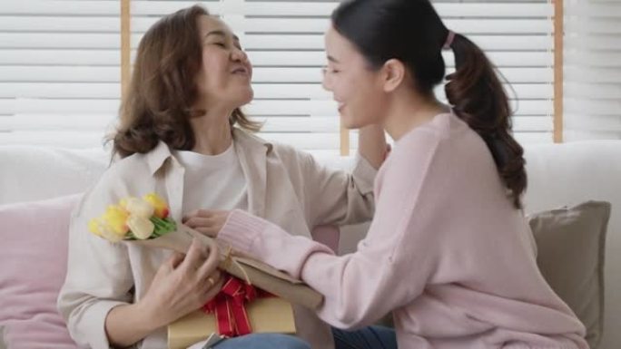 亚洲妈妈成人儿童儿童在家沙发上给拥抱亲吻礼物花