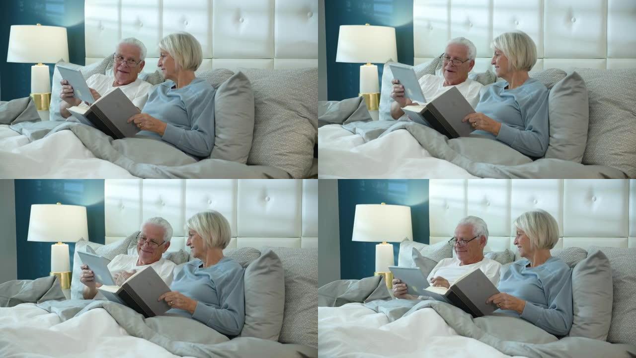 老年夫妇在床上读书，定期读书和电子阅读器