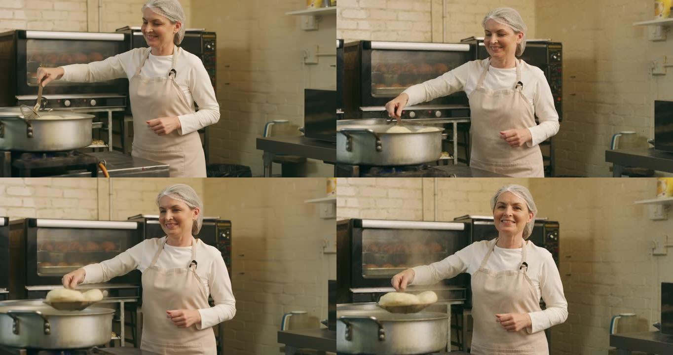 一个成熟的女性面包师在面包店的锅中煎炸百吉饼的4k视频片段