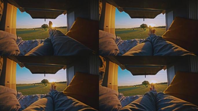 在阳光明媚的日子里，WS人躺在停在草地上的露营车的机舱里