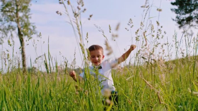 超级SLO MO小男孩在高草丛中奔跑时穿着带领带蝴蝶结的白衬衫