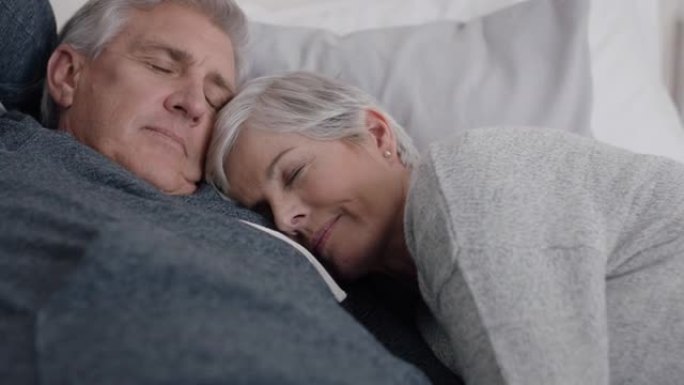 快乐的成熟夫妇躺在床上拥抱在一起休息，感觉累了，享受放松舒适的在家和平退休4k镜头