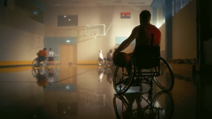 轮椅篮球比赛: 穿着红色衬衫的球员持球等待轮到他。运动员观看他的团队比赛。在这项运动中表现出色的残疾