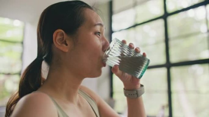 亚洲年轻女子在高强度锻炼后喝水补水