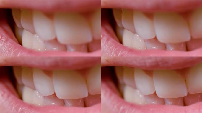 宏观: 一位年轻女子微笑时的明亮洁白的牙齿的特写镜头。