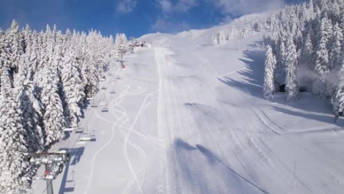 空中: 带有作业造雪机的积雪覆盖的封闭滑雪场的视图