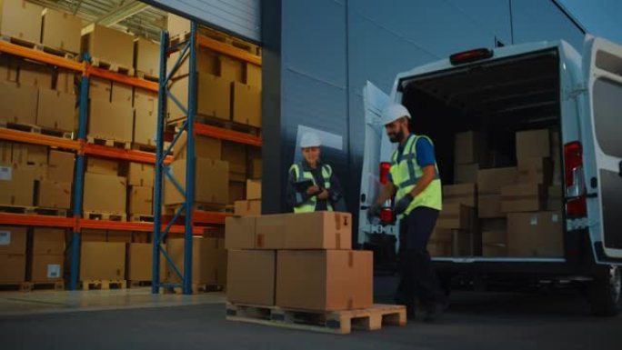在零售商分销仓库之外，库存经理使用平板电脑，与用纸板箱装载送货卡车的工人交谈。在线订单、采购、电子商