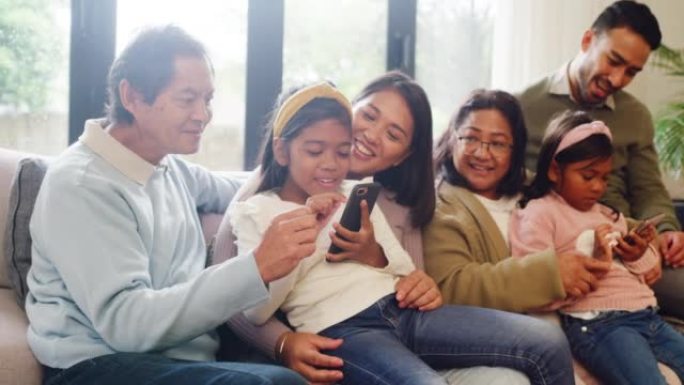 家人在家里的客厅里聚在一起，玩手机游戏或看在线电影。兄弟姐妹与父母和祖父母坐在沙发上时使用电话