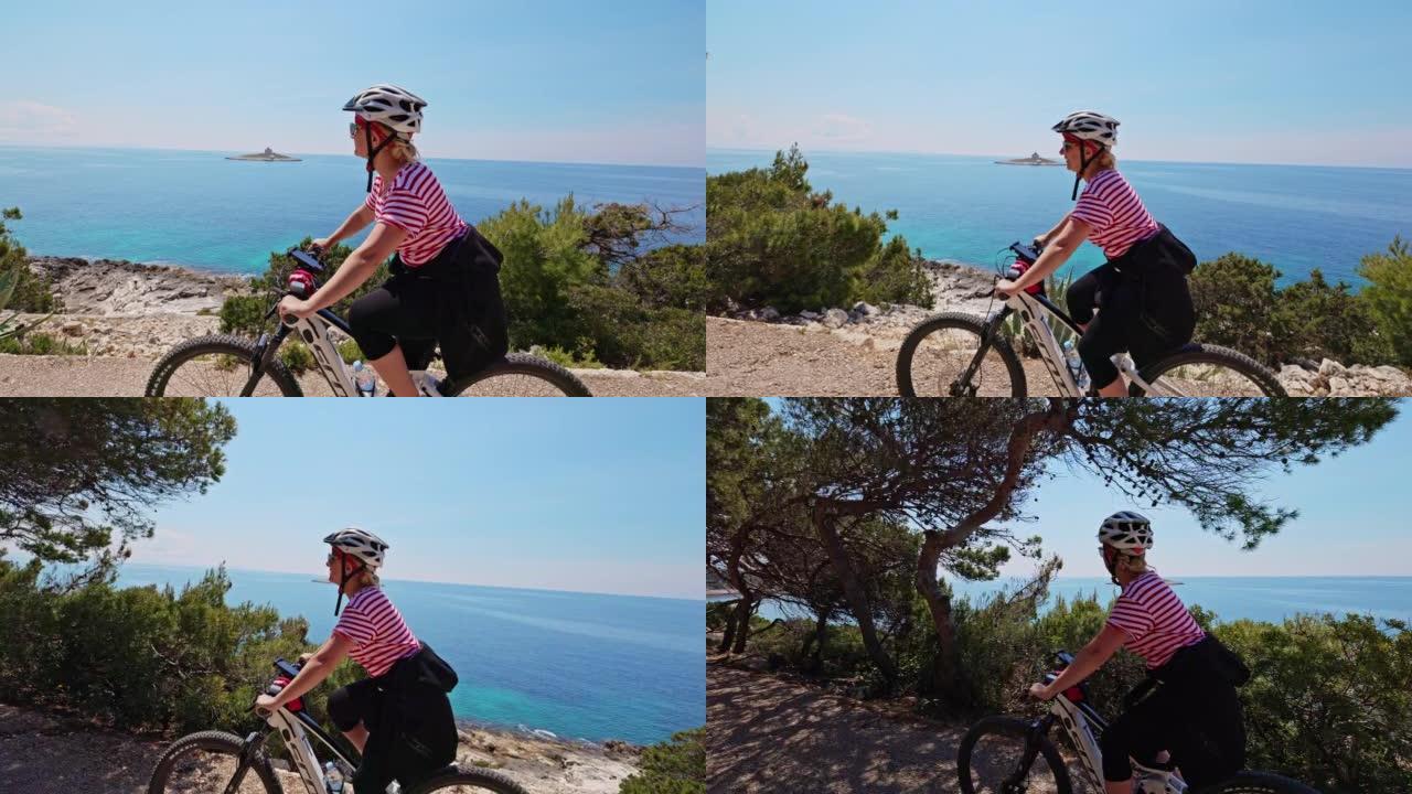 金发碧眼的女人在赫瓦尔岛 (Hvar island) 海岸骑自行车，放眼望去一个小岛，上面有一所房子