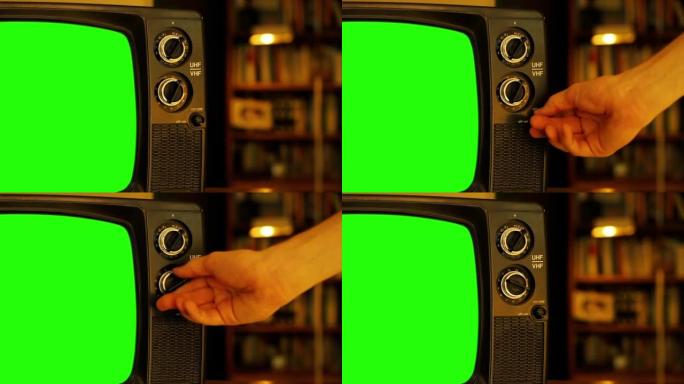 男人把手放在绿屏的旧电视上。特写。