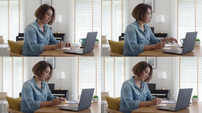 亚洲成人中年成熟妇女在家工作电脑笔记本电脑。