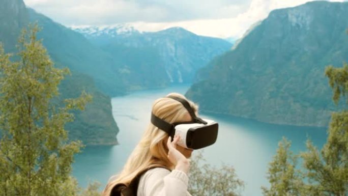 4k视频片段，一名年轻女子在探索m ø re og Romsdal时使用虚拟现实耳机