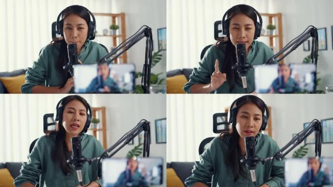 十几岁的亚洲女孩影响者使用麦克风佩戴耳机记录内容与智能手机在线观众在家里听。