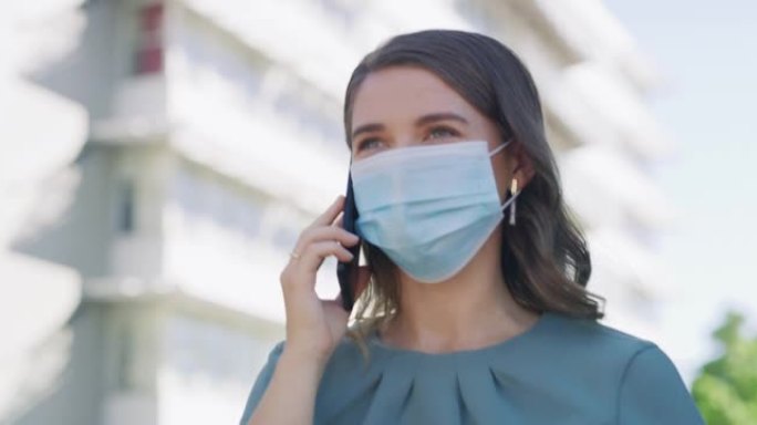 4k视频片段，一名年轻的女商人戴着口罩并在城市使用智能手机