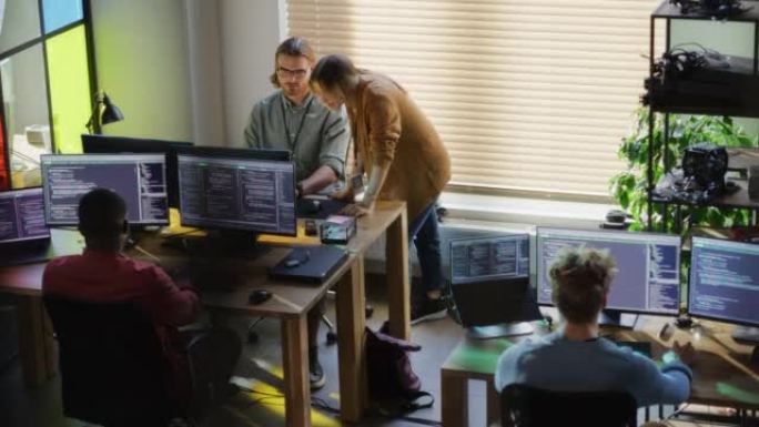 创意办公室: 在带有多个显示器的台式计算机上编码的各种同事。女性项目经理与男性团队负责人交谈，而初级
