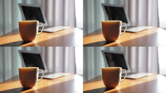 桌上有笔记本电脑的咖啡杯