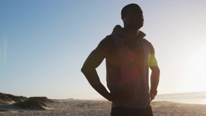 专注的非裔美国人在海边伸展运动，在户外锻炼