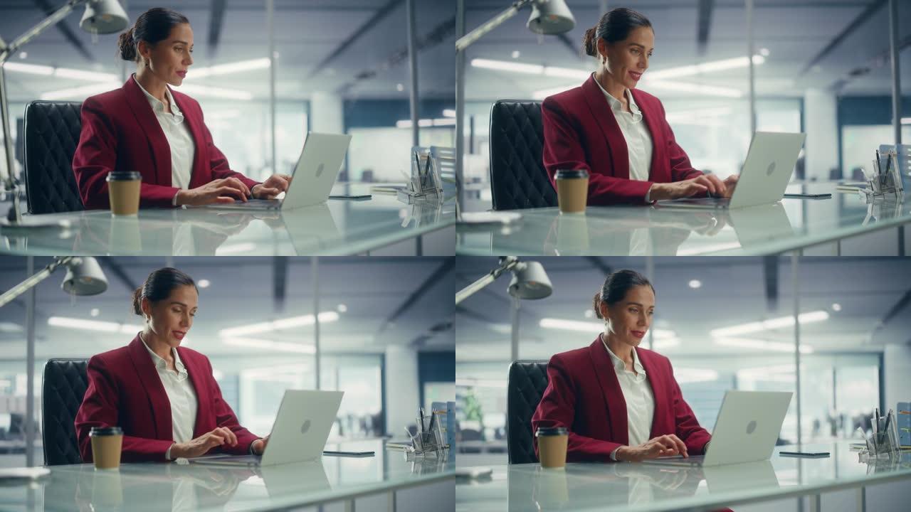 成功的白人女商人穿着完美时尚的西装，在俯瞰大城市的顶层办公室的笔记本电脑上工作。管理环境、社会和公司