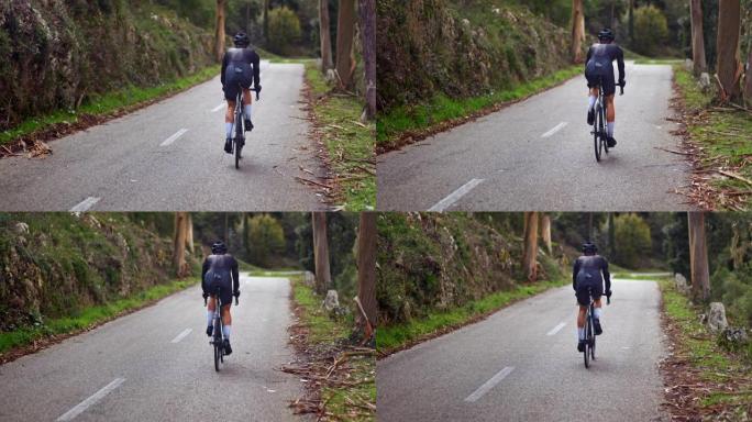 专业骑自行车的人在森林路上艰难地上坡