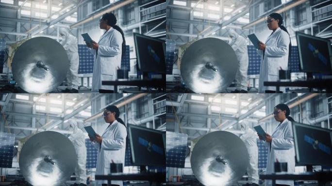 女工程师在进行卫星建设时使用平板电脑。航空航天局制造设施: 科学家为太空探索，观测任务建造，组装航天