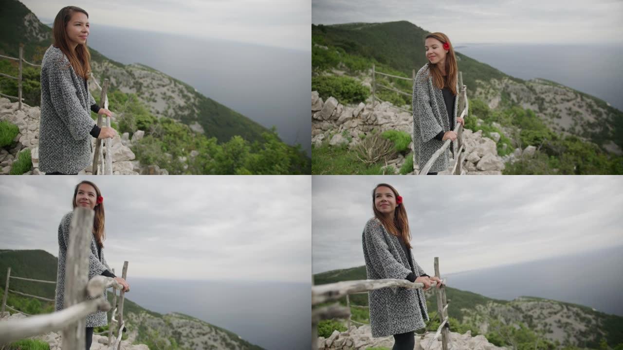 年轻女子站在山上欣赏风景