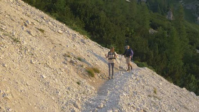 空中: 年轻夫妇在山上的碎石中徒步旅行