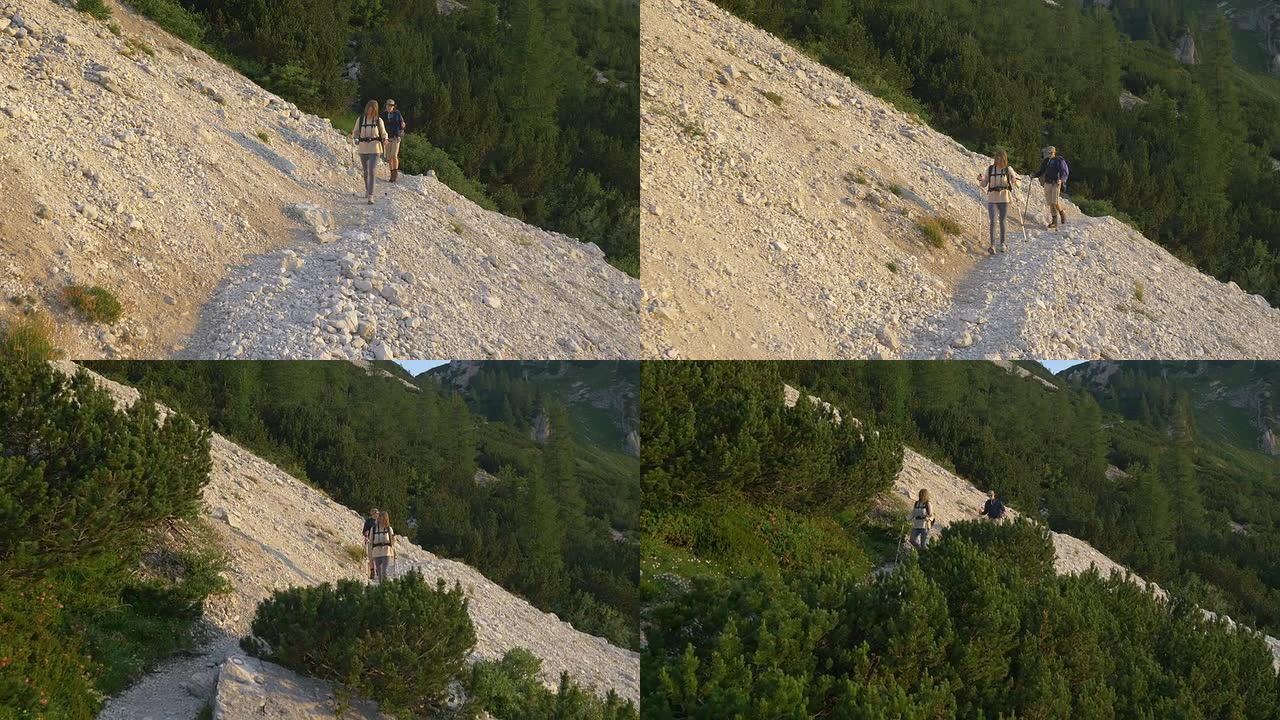 空中: 年轻夫妇在山上的碎石中徒步旅行