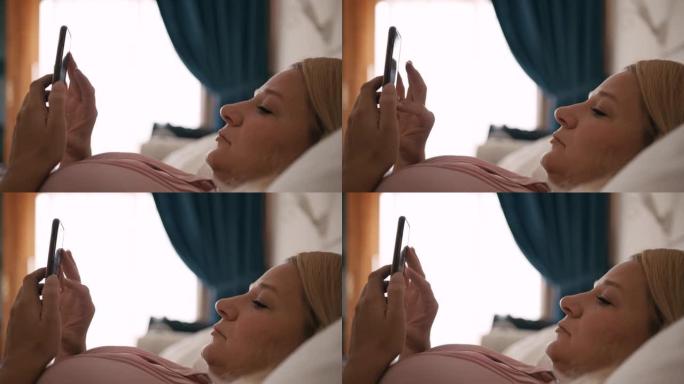 女士早上躺在床上时使用智能手机