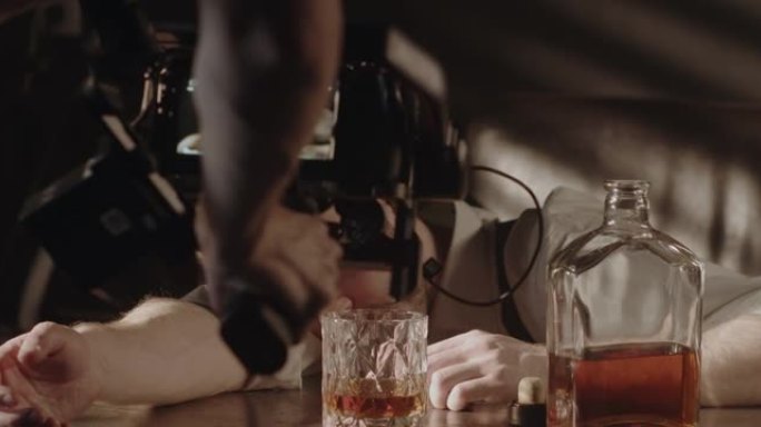 一个穿着衬衫的醉汉在黑暗的酒吧里睡着的场景的后台，用专业的相机制作了