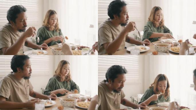 一对年轻的亚洲夫妇和朋友一起吃午饭。