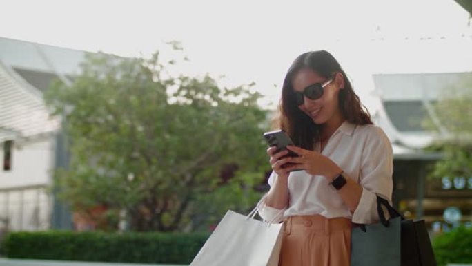 百货商店的年轻女子在智能手机上发短信