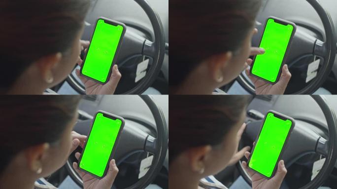 带色度键的汽车中使用智能手机的女性