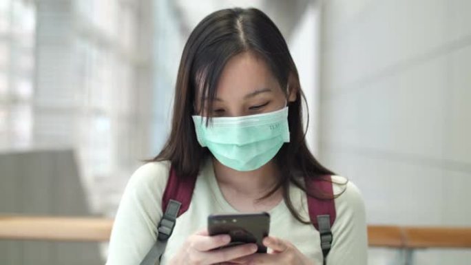 使用智能手机进行社交媒体的戴着口罩的亚洲女性