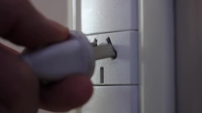 手动将电源线插入墙壁插座。特写。