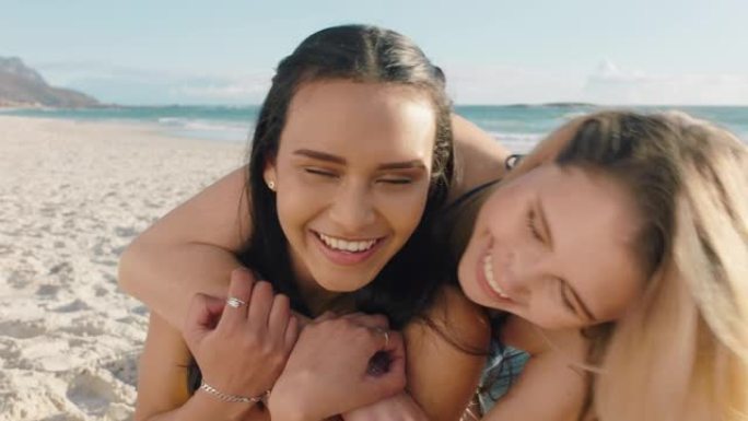 年轻女子在海滩上拥抱女朋友给惊喜拥抱最好的朋友玩得开心暑假