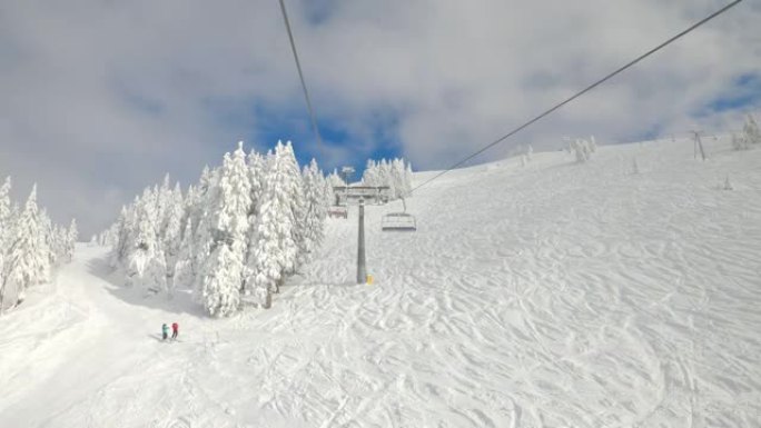 POV: 在斜坡上乘坐升降椅时，可以看到美丽的滑雪胜地的风景