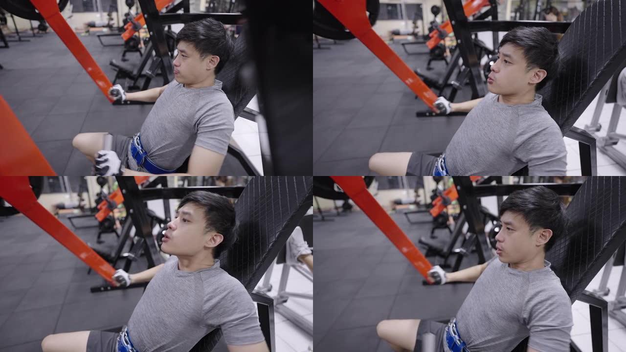 年轻运动员在健身房的坐式机器上做手臂和肩膀锻炼。