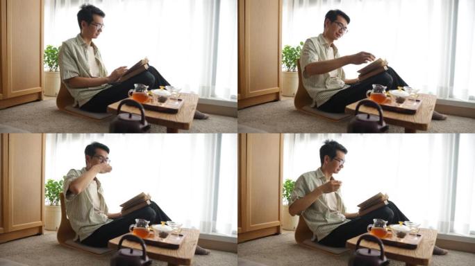 亚洲男子看书喝茶居家阅读中年男人喝茶读书
