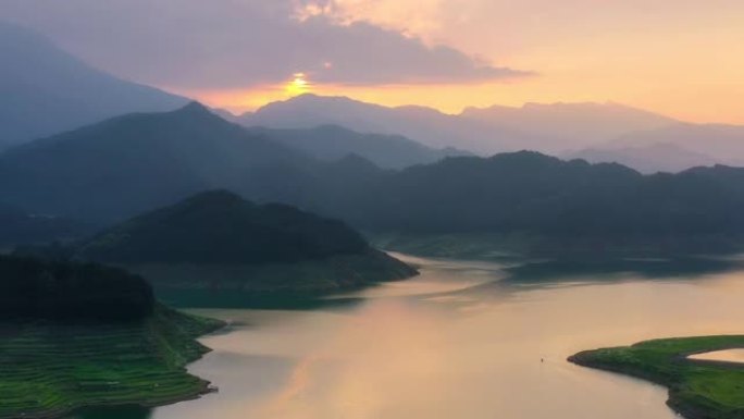 夕阳映照湖面，远处有山